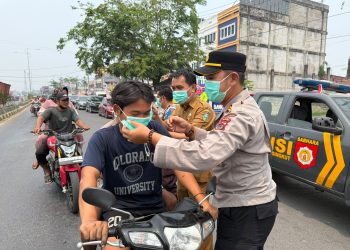 Kapolsek Pelawan Singkut dan Camat Singkut Bagikan Ratusan Masker di Tengah Kabut Asap